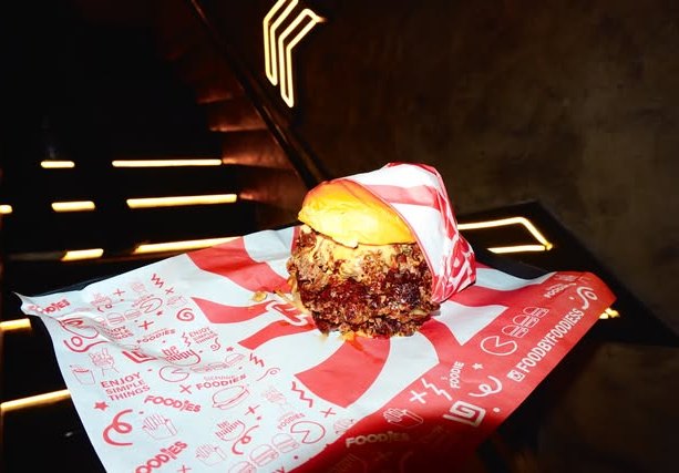 Hamburguesa sobre el papel de envoltura rojo y blanco de Foodies